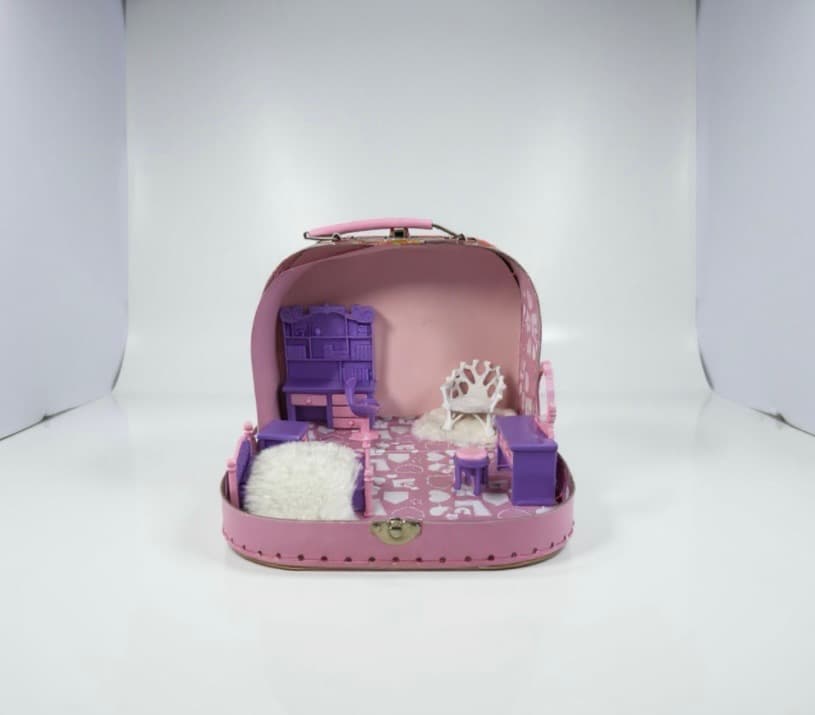 The room now has a fluffy white rug centred on the floor, a small white branch-shaped chair to the right of the dresser, and a round purple footstool on the left.